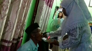 Nurkhotika saat memberikan kue ulang tahun dan menyuapi opung M.A.J Sihotang