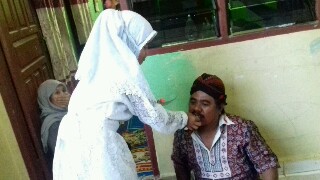 Nurkhotika saat menyuapkan kue ulang tahunnya ke ayahanda Mustafa Sihotang