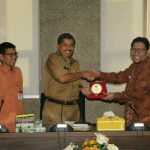 Anggota Komisioner Ombudsman RI Dadan Suharmawijaya memberikan cenderamata kepada Wakil Bupati Siak Alfedri diruang pertemuan Pucuk Rebung kantor Bupati Siak-640x449